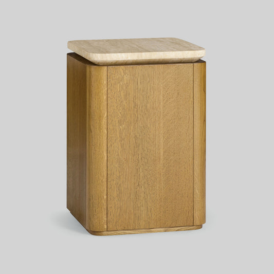 Wooden side table with a light finish and travertine top on a gray background.