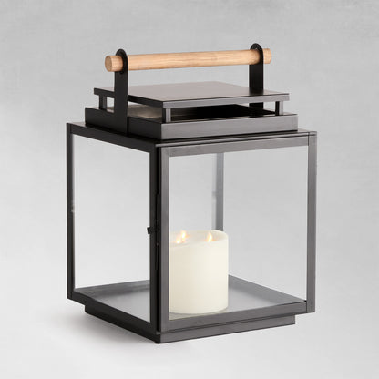 Large metal outdoor lantern with black finish with gray background.