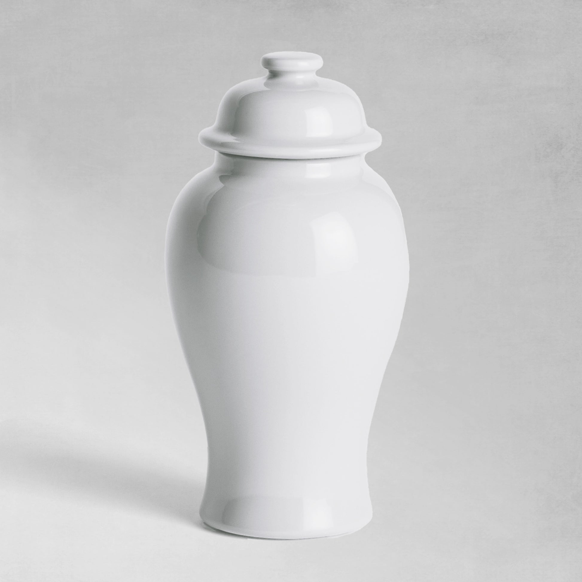 Mini white ceramic ginger jar with gray background.