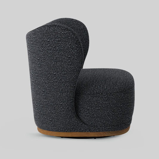 Dark gray boucle fabric lounge chair on gray background.