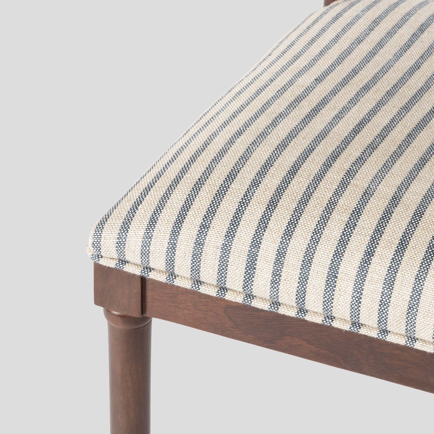 Chair with striped cushion and wooden frame on a gray background