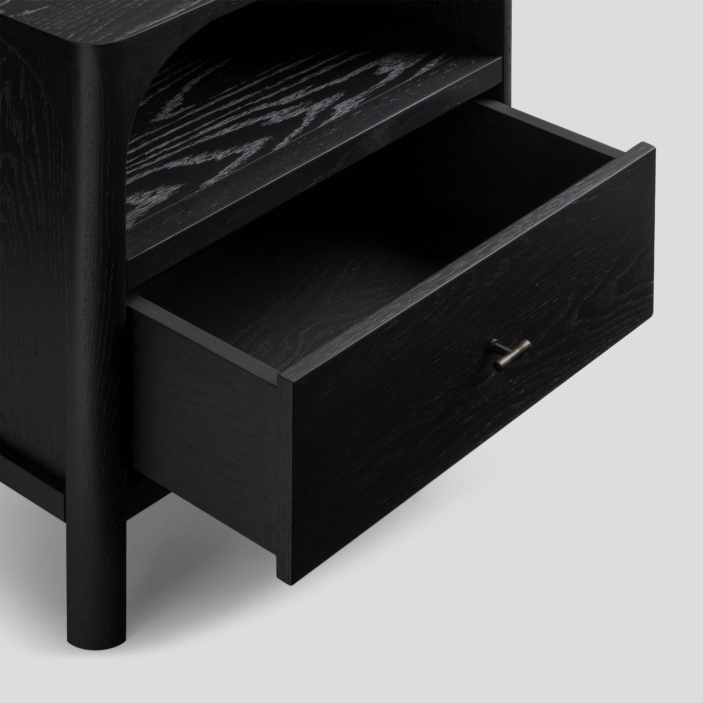 Black wooden nightstand with one drawer open on a light gray background
