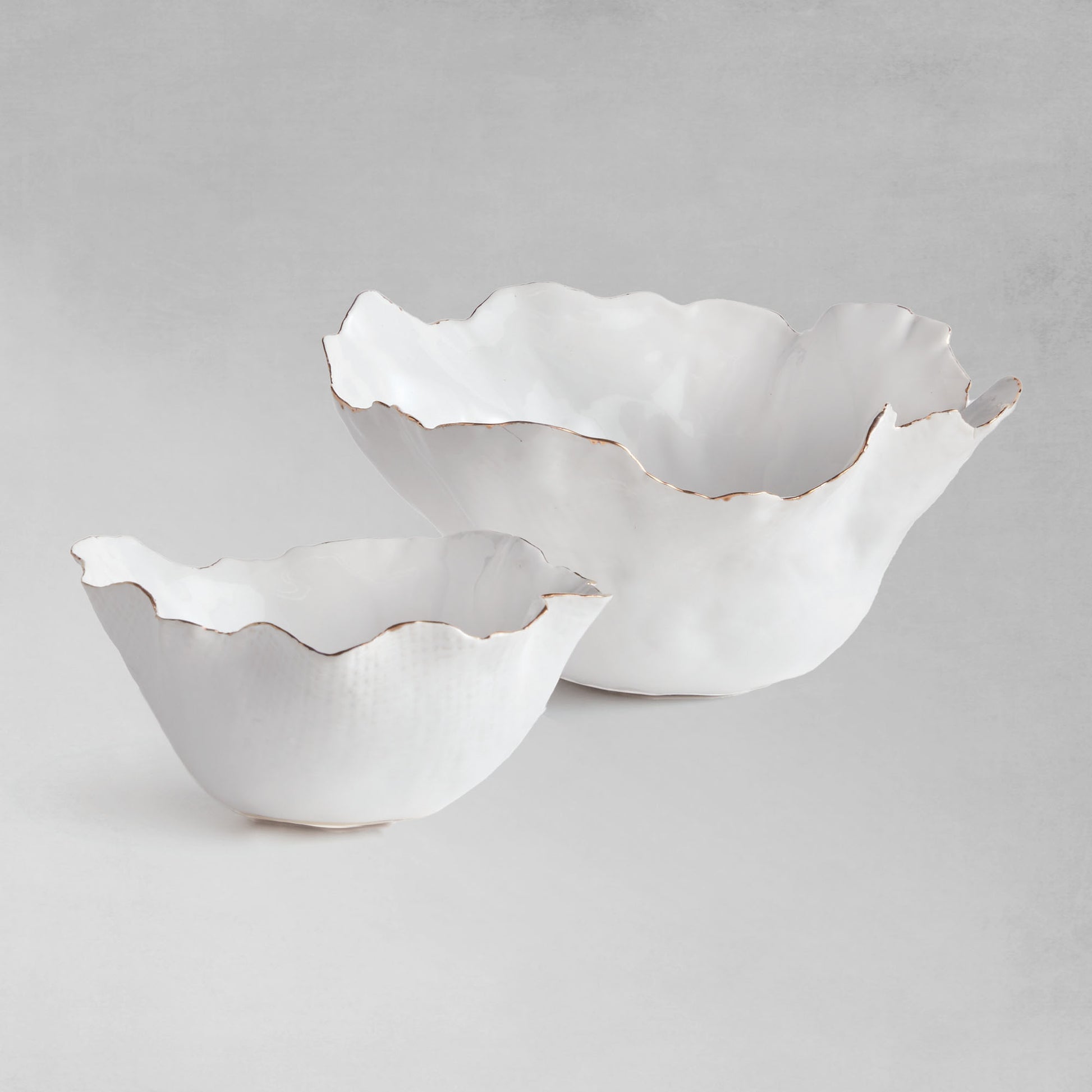 Organic decorative ceramic bowl set with gray background.