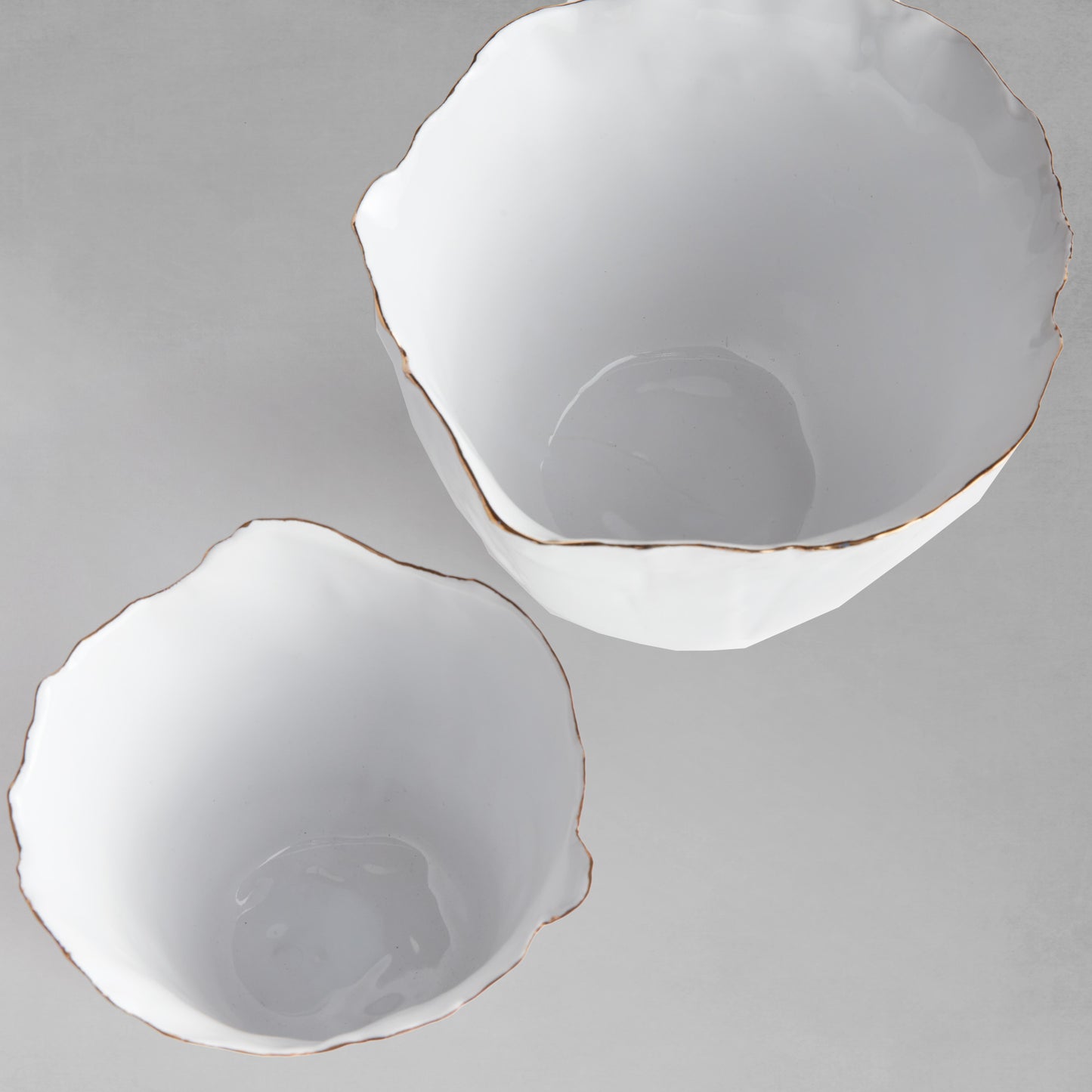 Organic white ceramic cachepots, set of two, top view, with gray background.