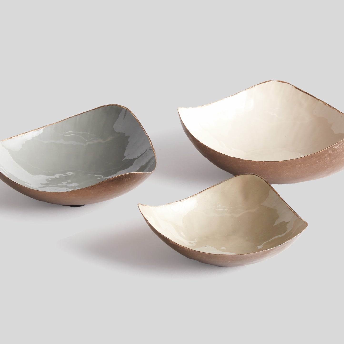 Set of 3 painted catchall bowls grouped together with gray background.