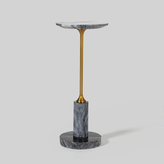 Small round cocktail table with marble top and brass base on a light gray background.