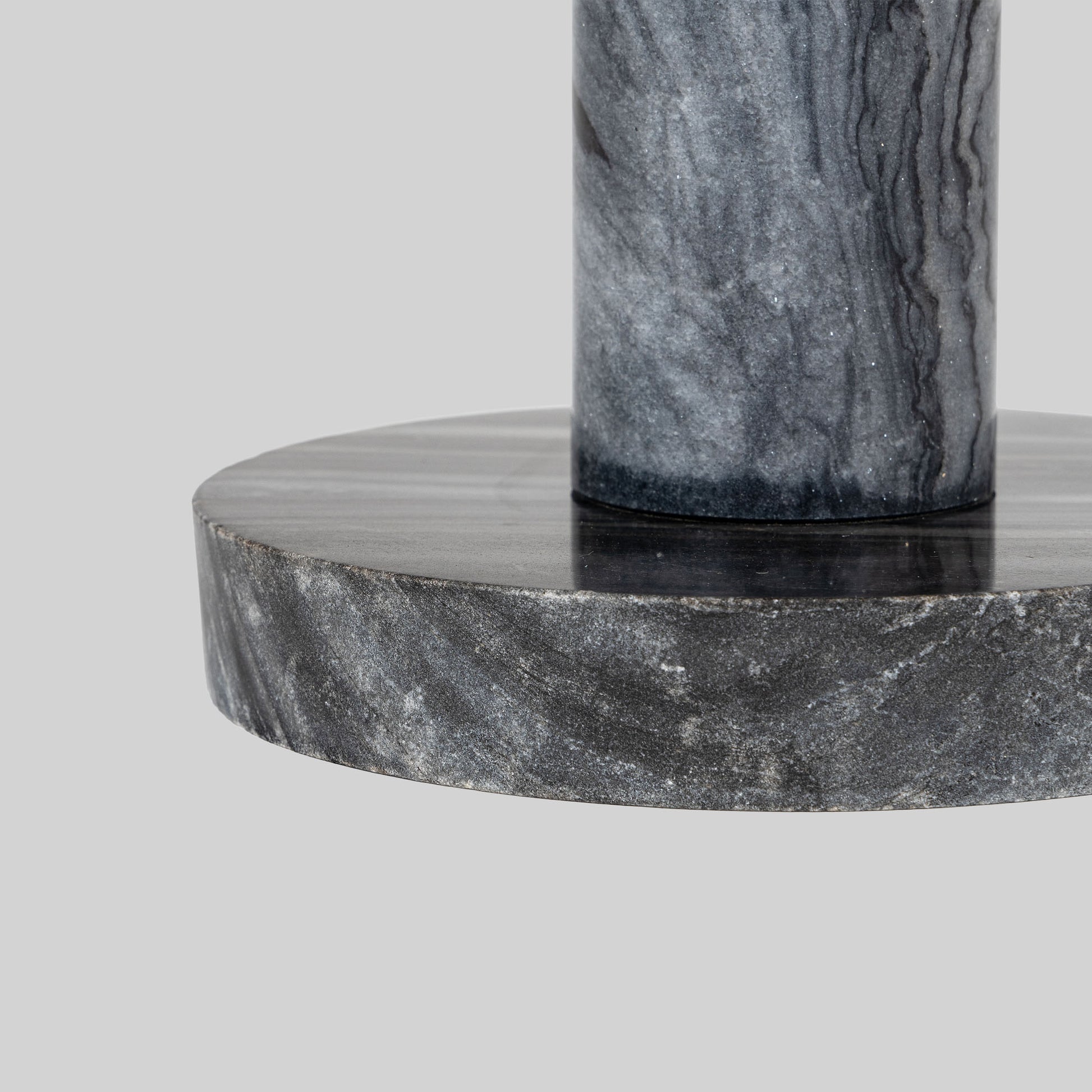 Small round cocktail table with marble top and brass base on a light gray background.