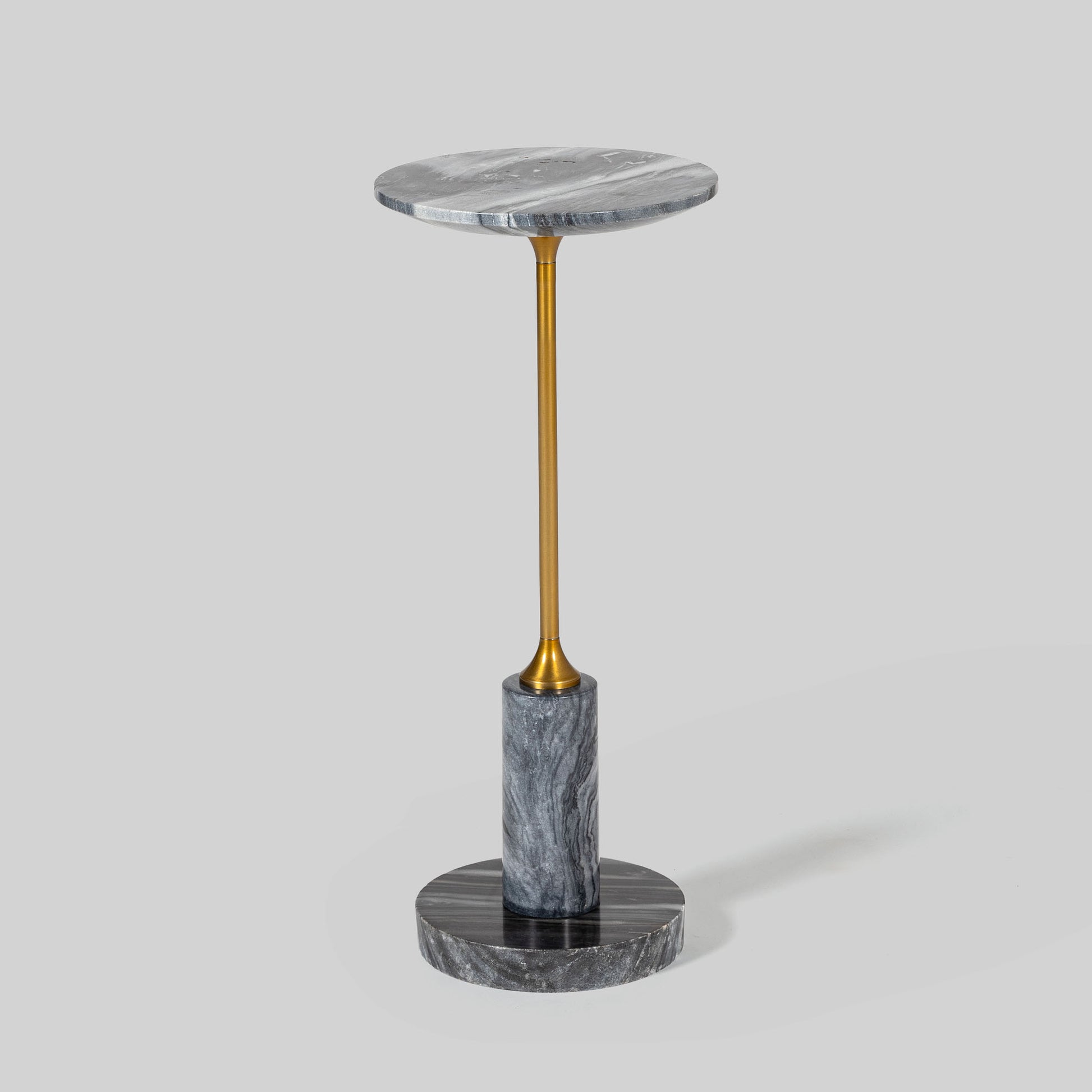 Small round cocktail table with marble top and brass base on a light gray background.