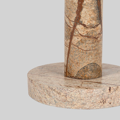 Small round cocktail table with marble top and brass base on a light gray background.
