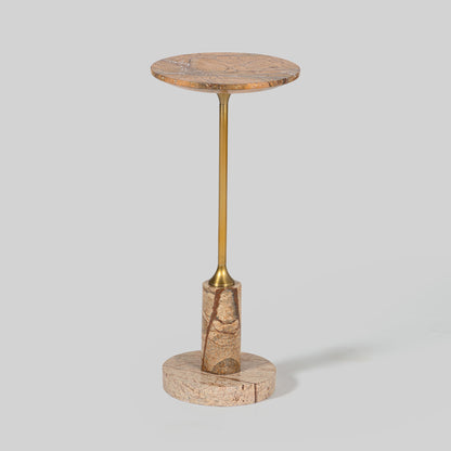 Small round cocktail table with marble top and brass base on a light gray background.
