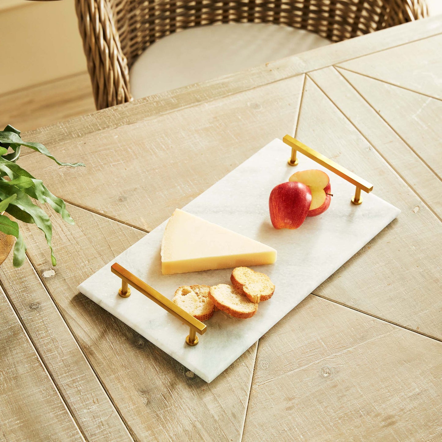 Rectangular marble serving tray with brass accents, top view, stylized with food on table.