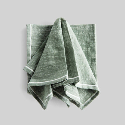 Sage green and white square cotton dinner napkins set of 4 with gray background.