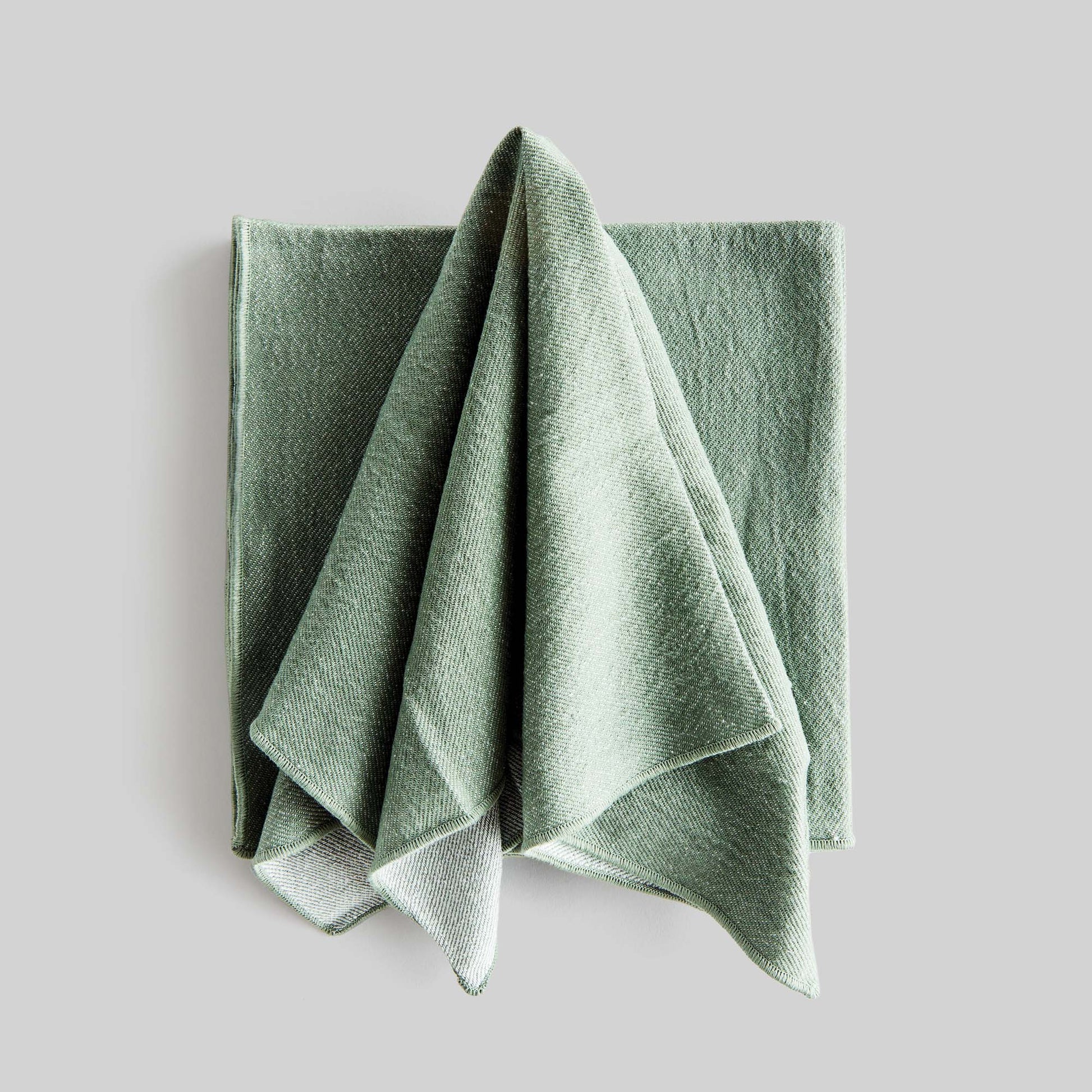 Sage green square cotton dinner napkins set of 4, unfolded, with gray background.