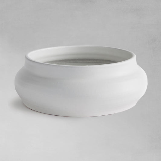 Smooth white decorative terracotta bowl with gray background.