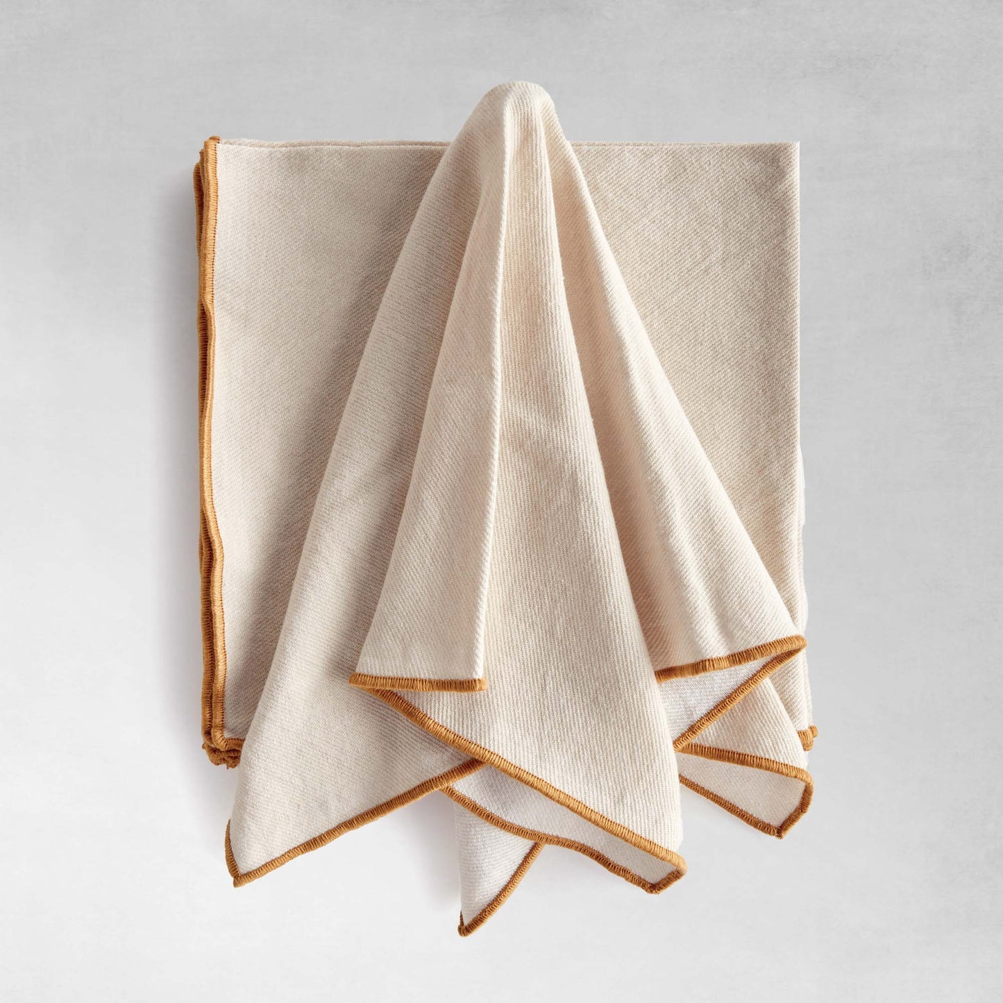 Tan square cotton dinner napkins, set of 4, with gray background.