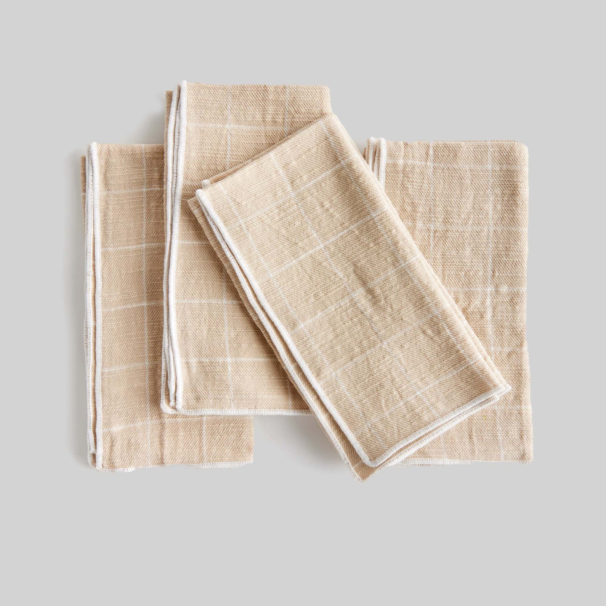 Tan windowpane square cotton dinner napkins set of 4 with gray background.