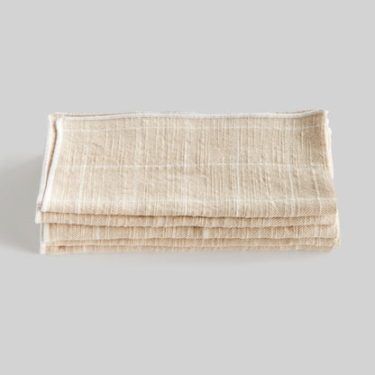 Tan windowpane square cotton dinner napkins set of 4, stacked and folded, with gray background.