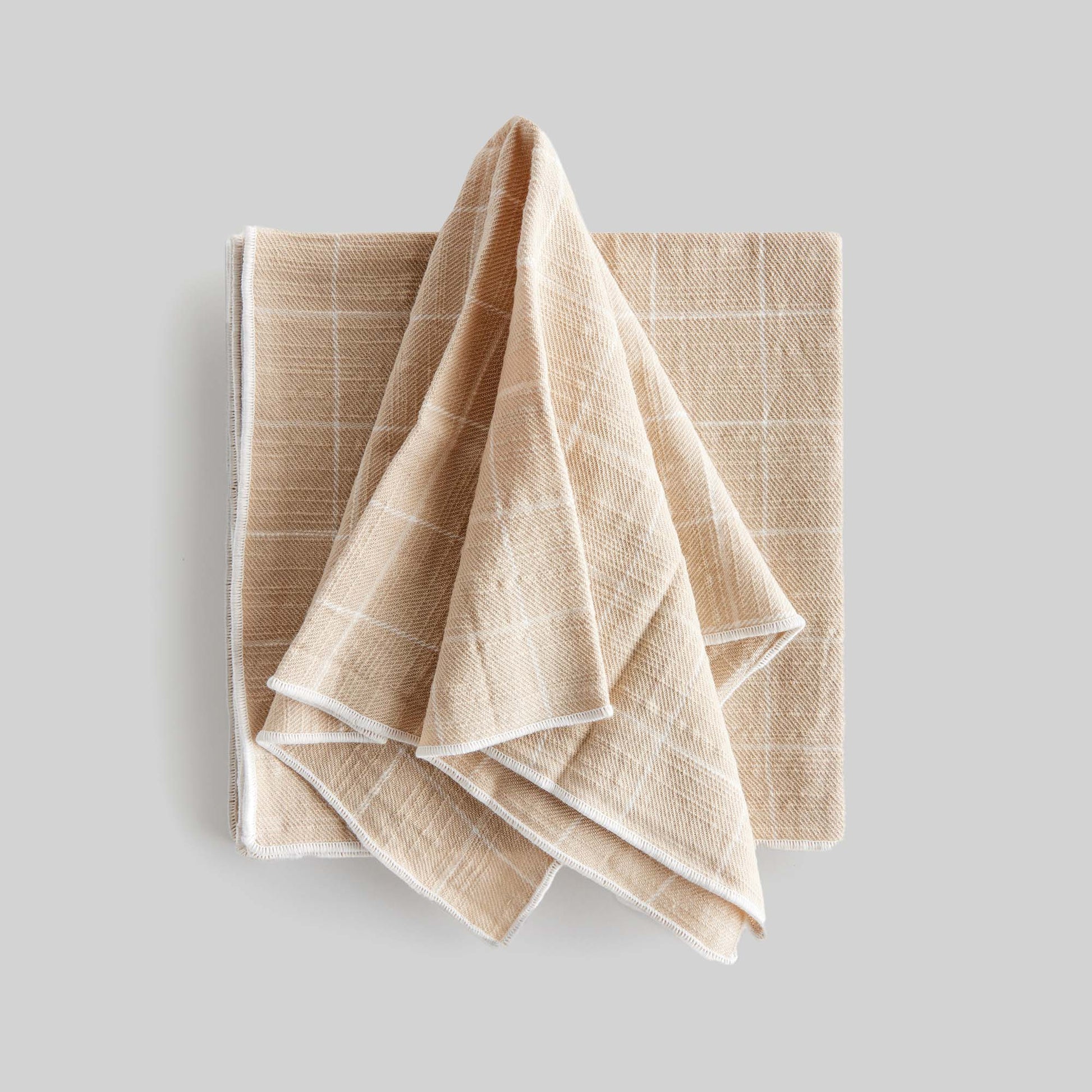 Tan windowpane square cotton dinner napkins set of 4, unfolded with gray background.