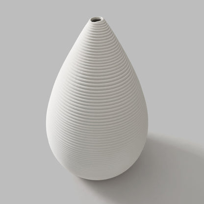 White ceramic vase with ribbed texture on a gray background