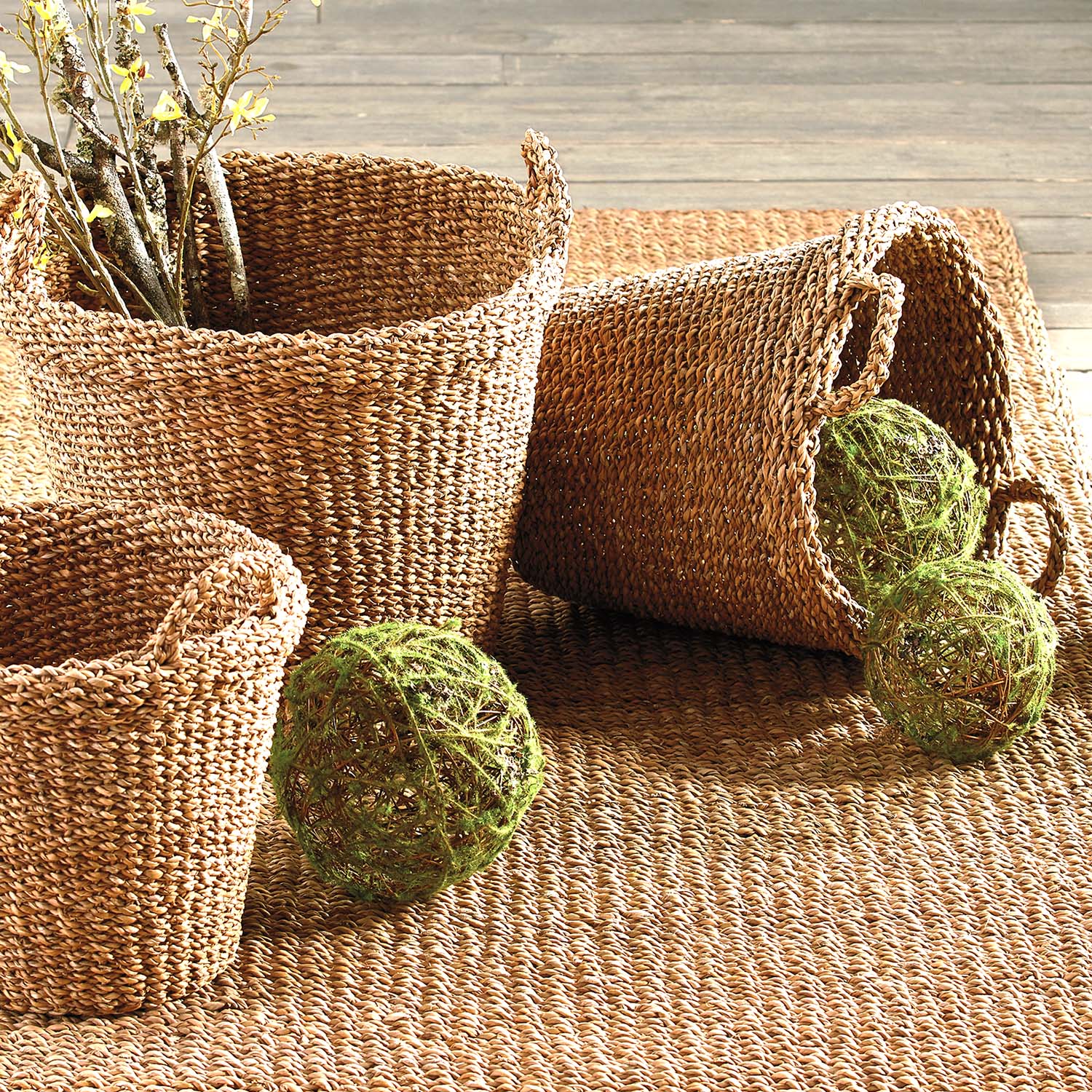 Tapered woven seagrass baskets stylized on rug.