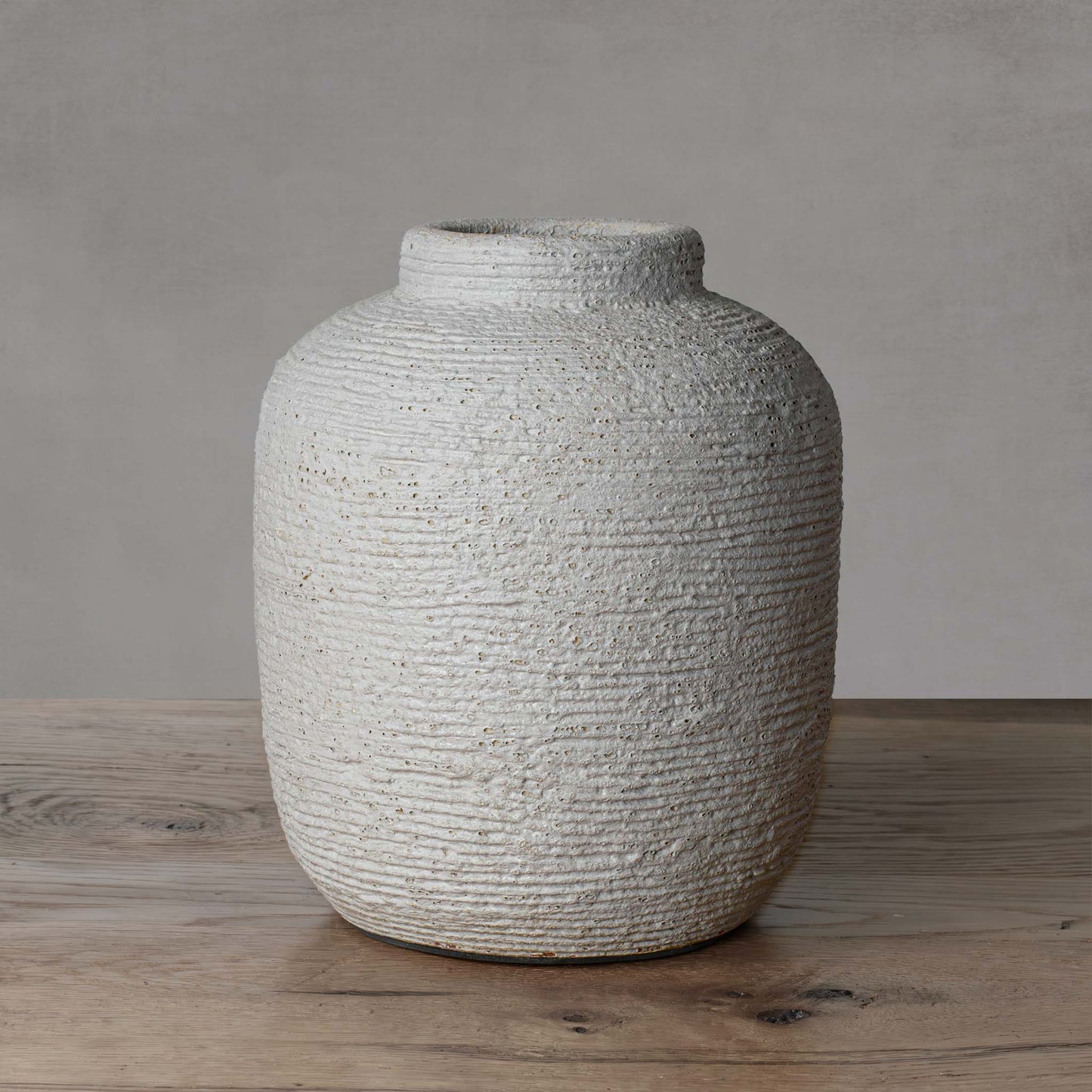 Medium textured cement decorative vase with light gray background.