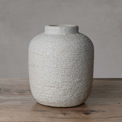 Medium textured cement decorative vase with light gray background.