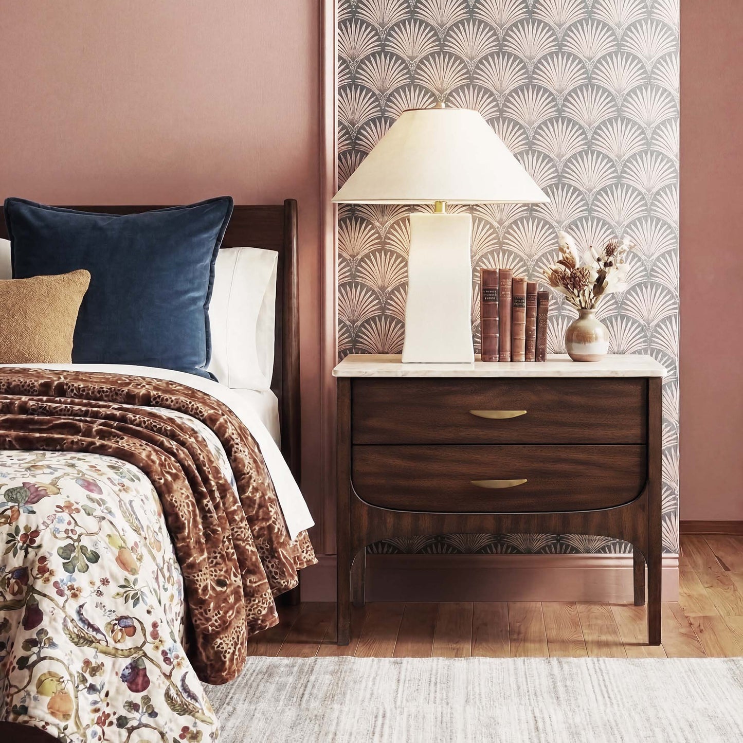 Bedroom with wooden nightstand, lamp, and decorative items against a patterned wall.