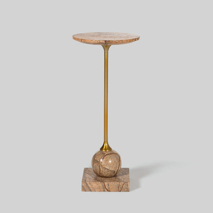 Small round cocktail table with marble top and brass base on a light gray background.