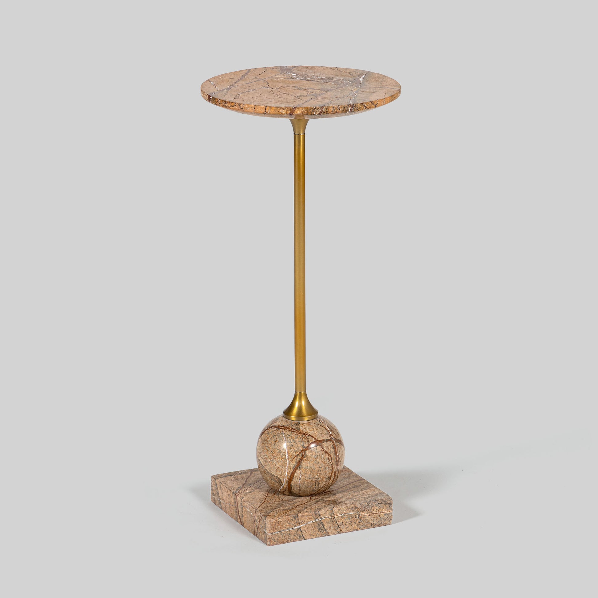 Small round cocktail table with marble top and brass base on a light gray background.