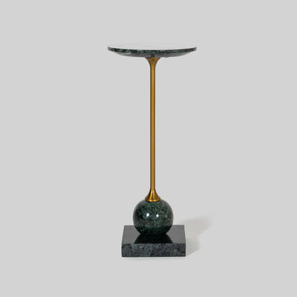 Small round cocktail table with marble top and brass base on a light gray background.