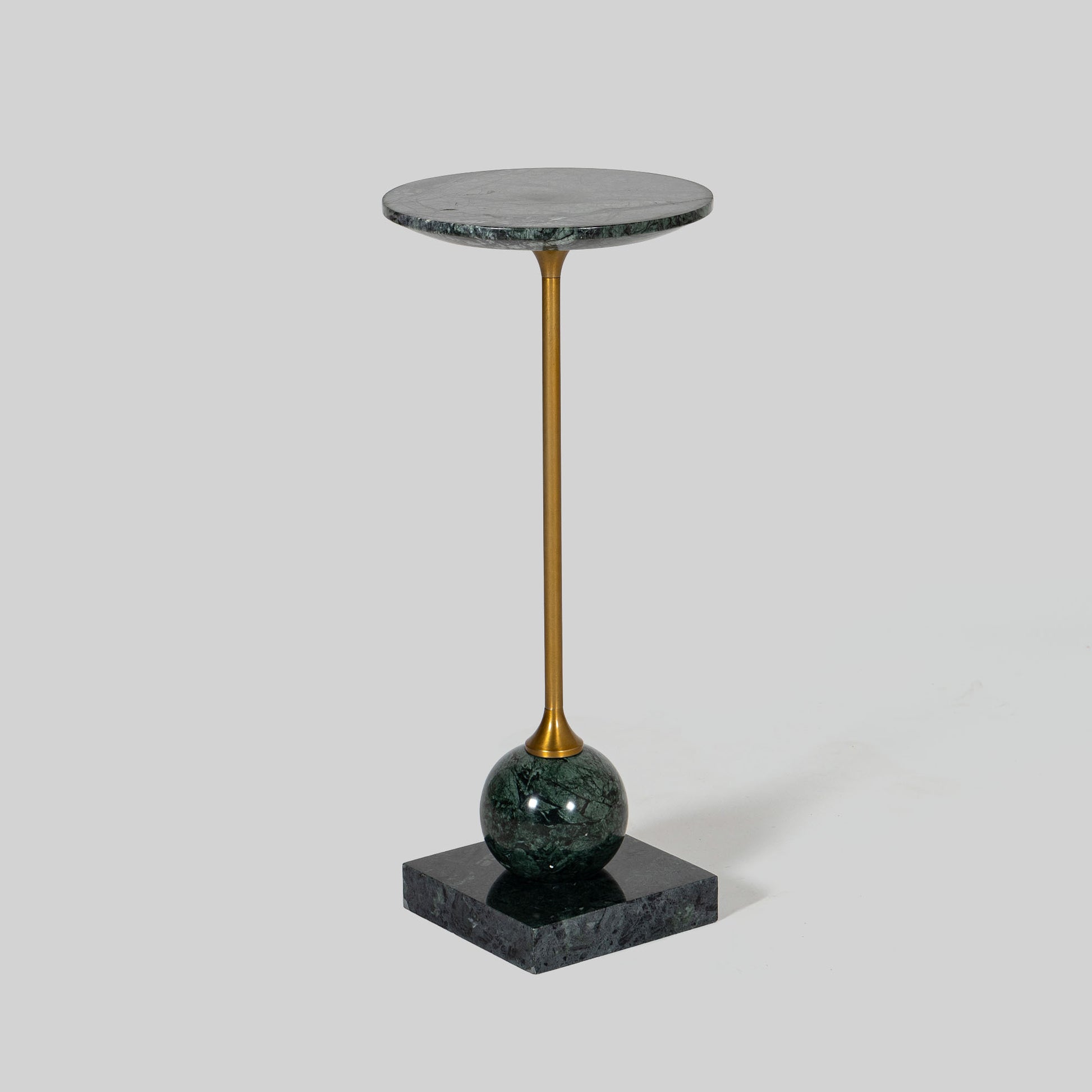 Small round cocktail table with marble top and brass base on a light gray background.