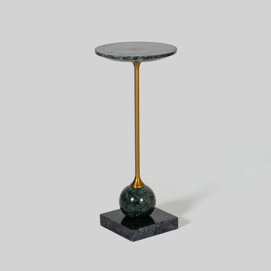 Small round cocktail table with marble top and brass base on a light gray background.