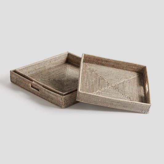 Woven square ottoman tray set in rattan with whitewash finish, gray background.