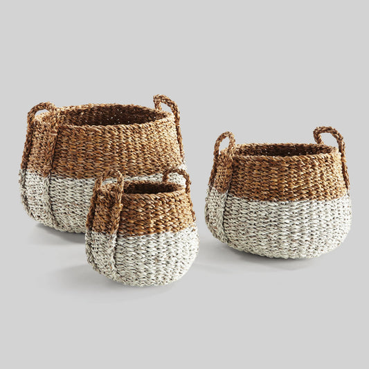 Woven two-tone seagrass baskets with gray background.