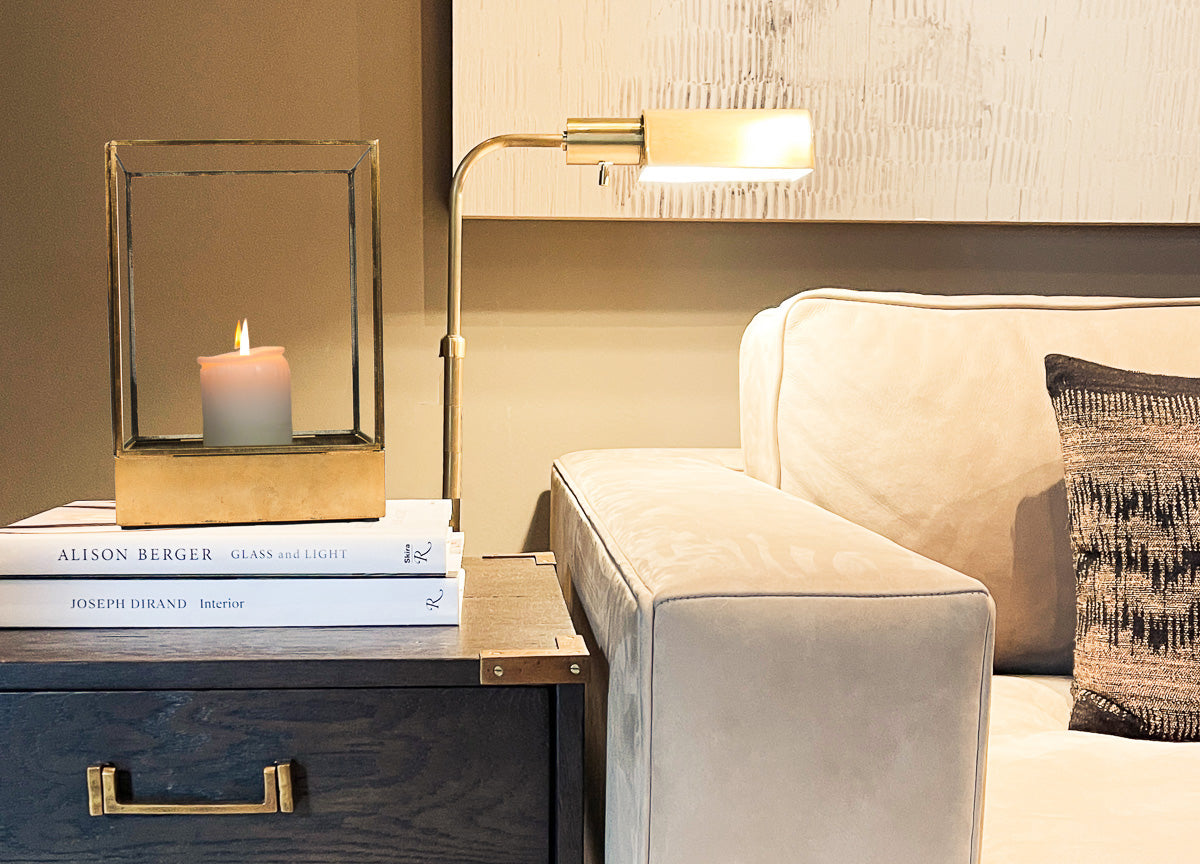 Antique brass and glass hurricane candle holder on side table in living room